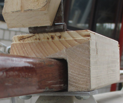 Das Holz wird über den Handlauf gestülpt und mit der Metallzunge fixiert. Anschließend wird es Richtung Heck gegen die Handlaufstütze geschoben.